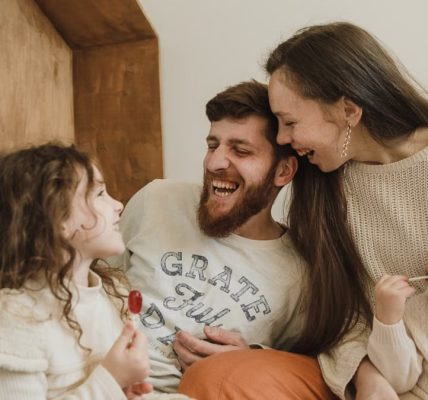 Happy family enjoying quality time with their children indoors, sharing laughter and joy.