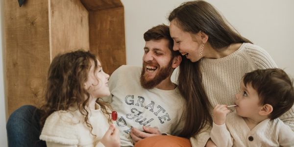Happy family enjoying quality time with their children indoors, sharing laughter and joy.